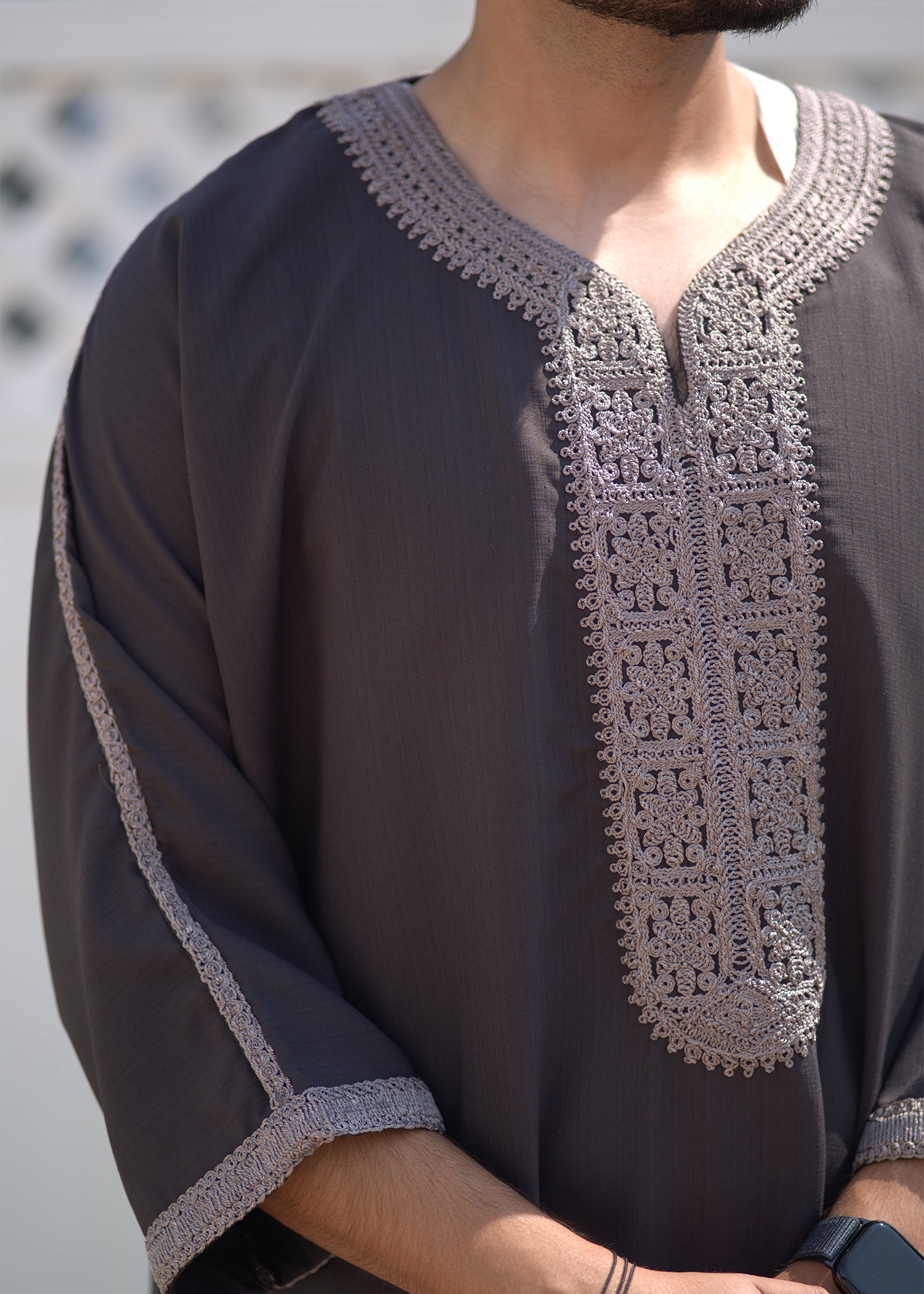 Side view of the model wearing the thobe, showing the functional side pockets and the characteristic loose fit.