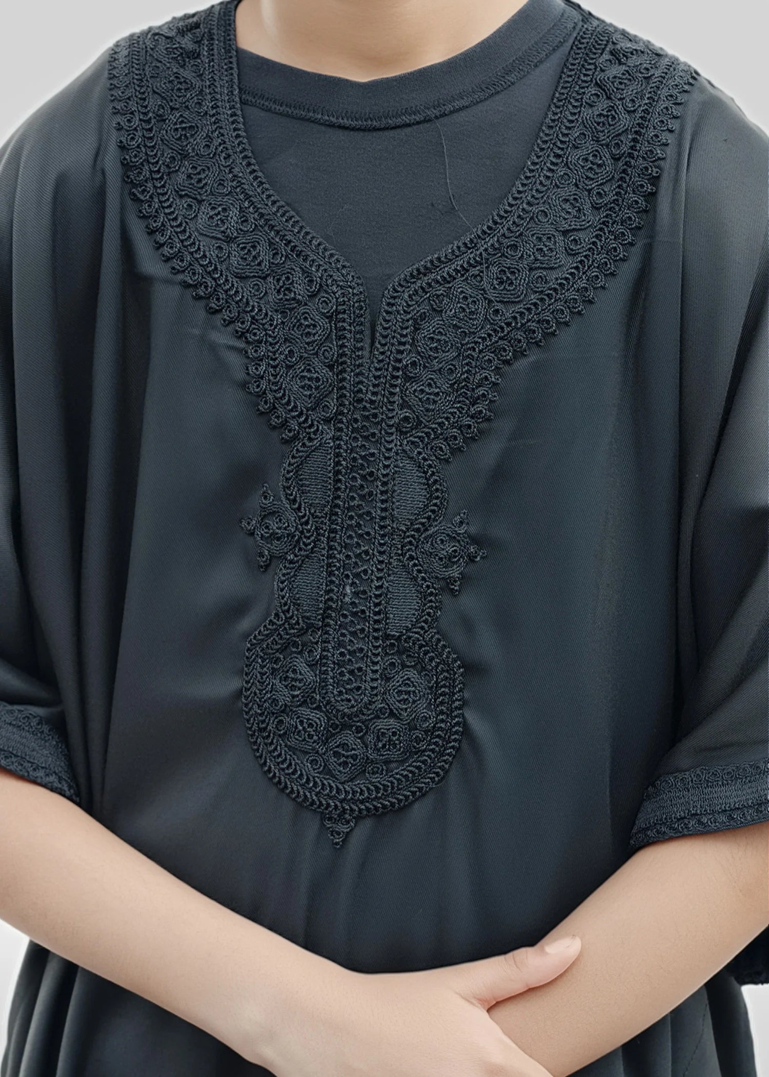 Close up of the intricate black embroidery around the neckline of the moroccan boys thobe
