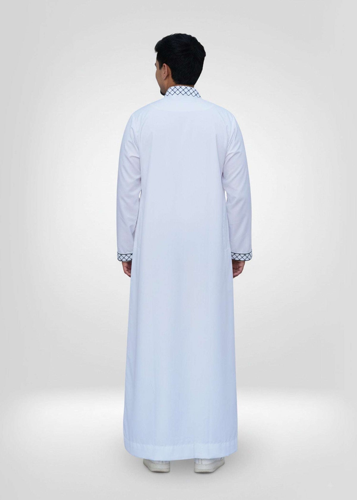 White Palestine embroidered thobe with Kufiya detailing for men, worn by a model outdoors